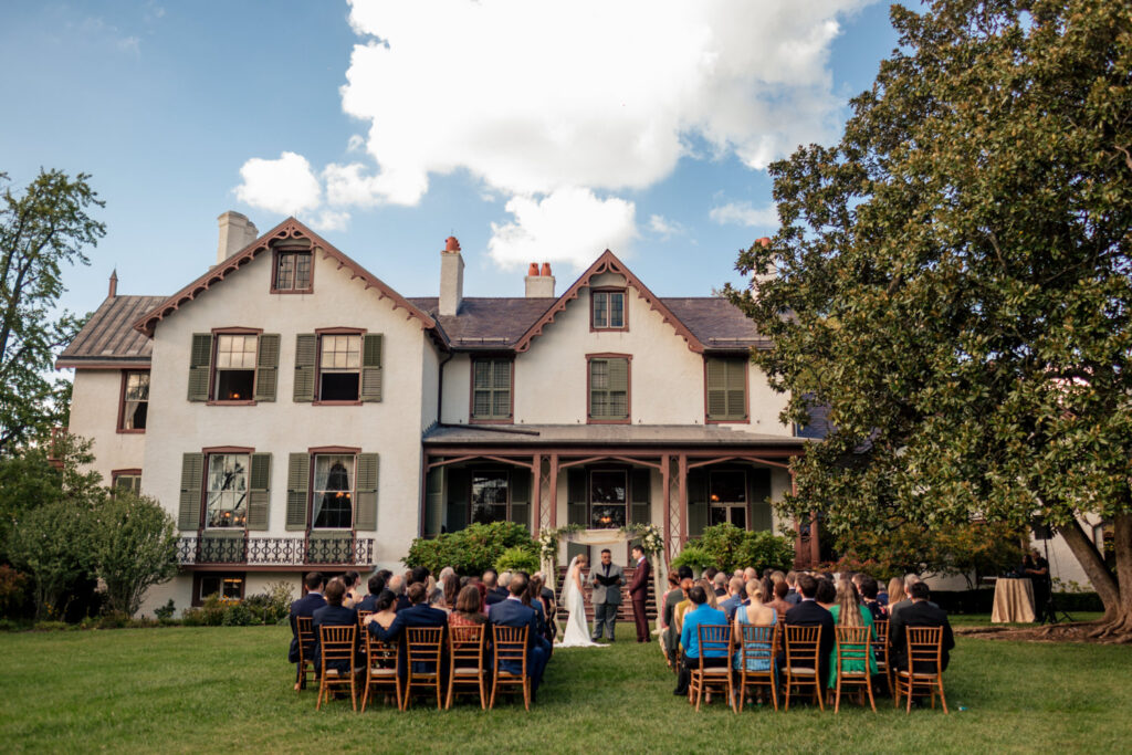 Outdoor wedding ceremony setup at President Lincoln’s Cottage with a magnolia tree and the historic house in the background