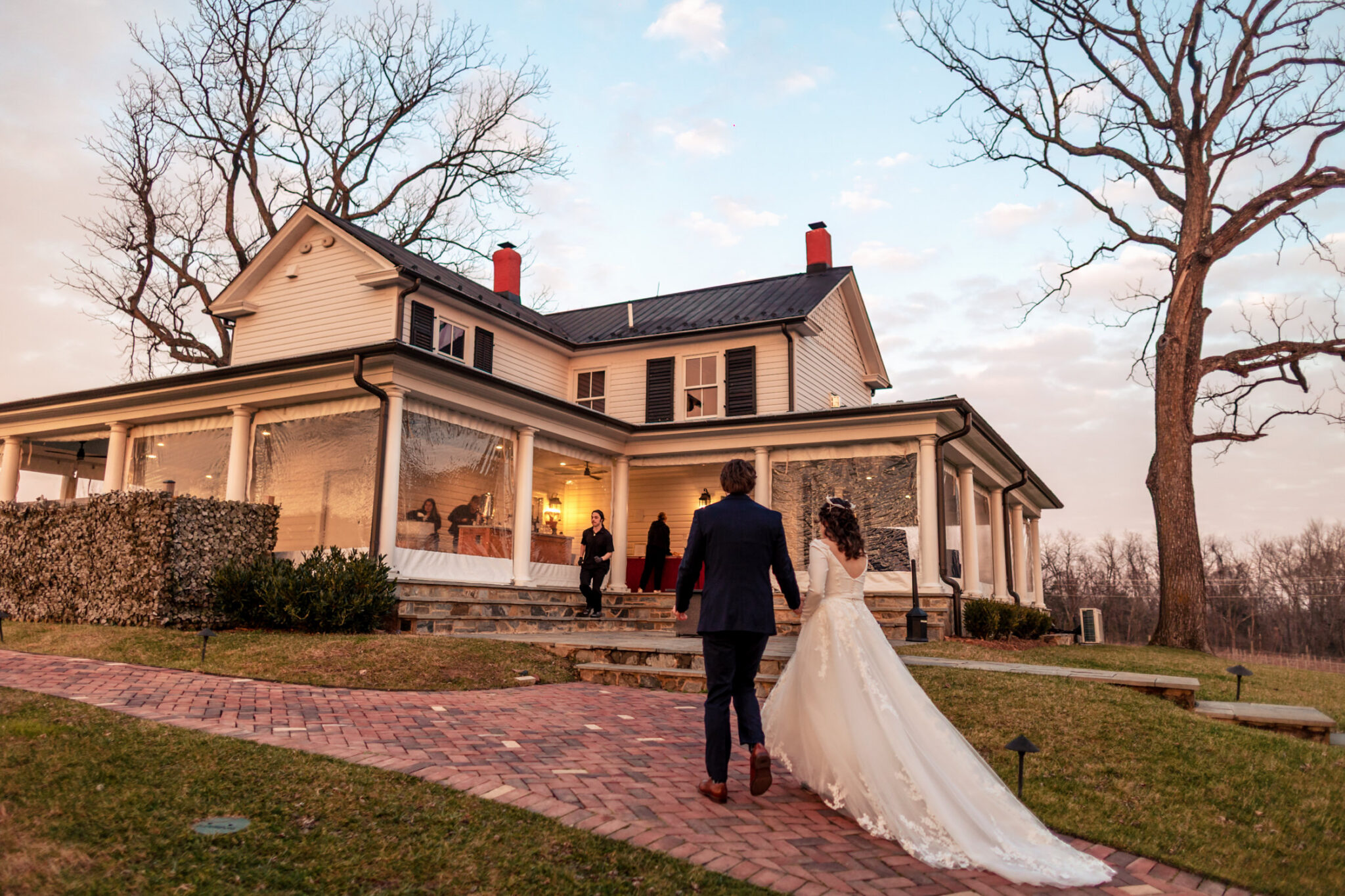 The couple is walking to the main house of Old Farm Winery at Hartland during their wedding.